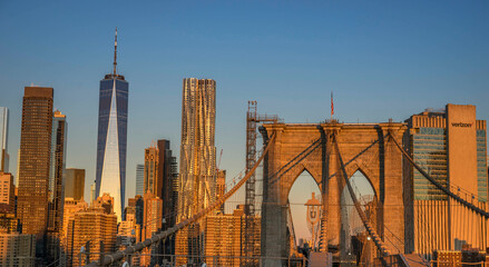Brooklyn Bridge over East River viewed from New York City Lower Manhattan waterfront at sunrise