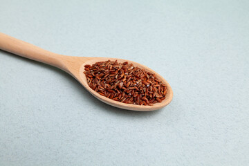 Brown GABA rice in long wooden spoon, close-up. Selective focus, space for text