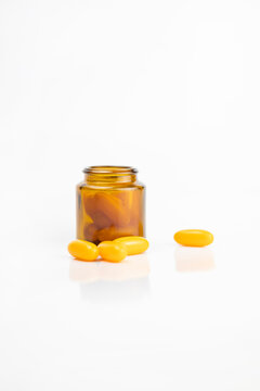 yellow omega 3 medication capsules for treatment in bottle packaging on isolated white background