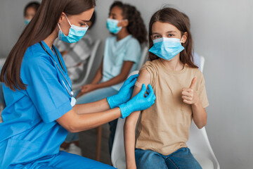 Girl Getting Vaccinated Gesturing Thumbs Up Approving Coronavirus Vaccine Indoor