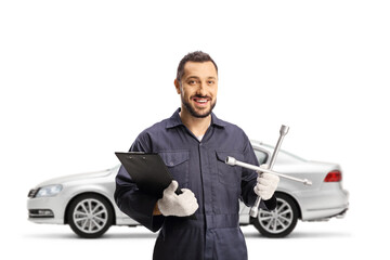 Auto mechanic worker holding a lug wrench in front of a silver car