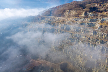 Landscape morning fog on mountain with quarry extracting stone
