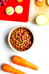 food for pets with meat and eggs on kitchen background top view