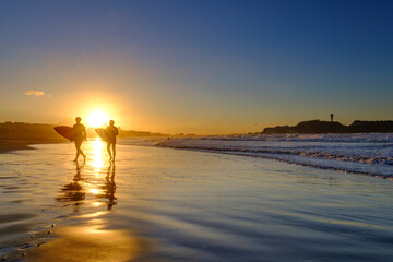 江の島の朝陽とサーファー