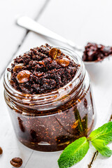 Homemade cosmetics with scrub and coffee beans on desk background