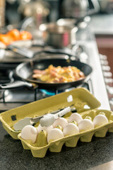 Close up of an egg package with the stove cooking in the background