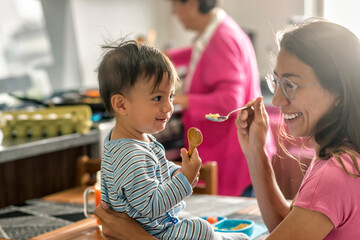 Cute latin Mom sharing smiles with her son at breakfast