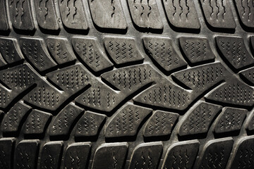 Used rubber tyre texture. Junkyard closeup dumped car wheel. Tire tread pattern. Black shiny rubber...