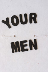 grungy sign with the words "your men" spelled out in black chalk letters 
