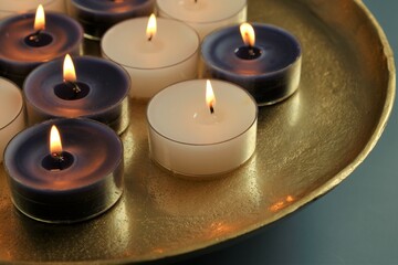 Candle flame. Burning candles set in a round gold tray on a dark blue background.Candles background. 