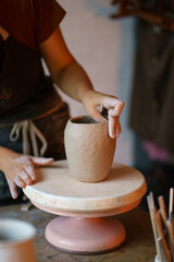 Focus on art and handicraft: cropped image of female concentrated sculpturing potter tableware in studio. Woman visit ceramics classes after work for stress relief and relax. Hobby and therapy concept