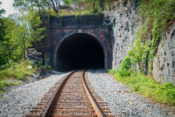 railway line leaving in a dark tunnel.