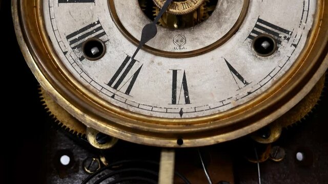 Old pendulum clock stopped ticking by person's hand