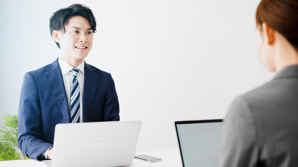 Obraz premium 仕事をしながらコミュニケーションを取るビジネスマンとビジネスウーマン