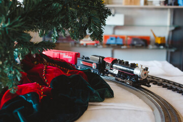 A model train and track ride around a Christmas tree in a shop