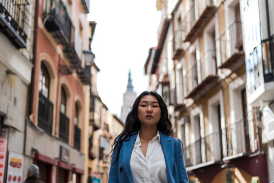 Asian businesswoman walking down a central street in the city