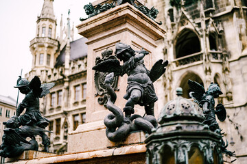 Fototapeta na wymiar Angel defeating a dragon at a column. Statue at Marienplatz in Munich