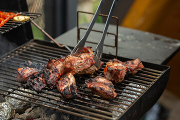 A barbecue grill with tasty juicy steaks are grilled over an open fire.