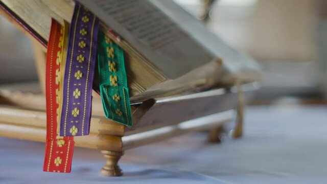 Old Bible on Alter in Church with gold leaf pages and decorative bookmarks
