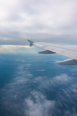 View from the airplane window at a beautiful blue sunrise and the airplane wing in clear sky.