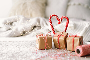 Merry Christmas. Ready Christmas card. Christmas gifts and sweet candies in the shape of a heart. Christmas background with garlands and New Year decorations.