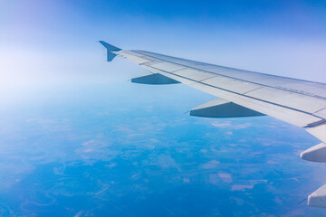 View from the airplane window at a beautiful cloudy sky and the airplane wing