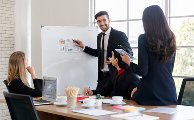 Positive businessman showing charts to faceless colleagues