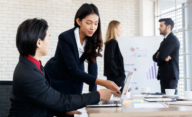 Cheerful Asian colleagues near business people