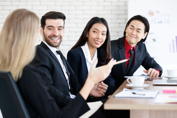 Cheerful multiethnic colleagues at table in boardroom