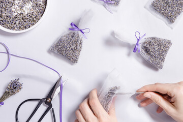 Making DIY lavender sachets for home, for gifts, natural scented bags from organza on white...