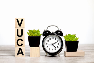 VUCA. text on wooden boards on a white background on a wooden table