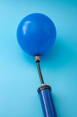 Party accessory, fun decoration and financial bubble with pump inflating a latex balloon isolated...