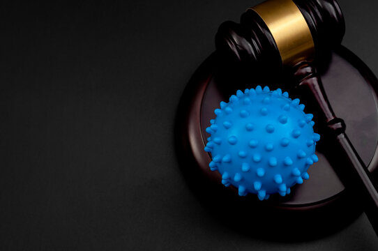 Legality of federal vaccine mandates, covid19 public health crisis and impact of mandatory covid vaccines concept with coronavirus model and judge gavel isolated on black background with copy space