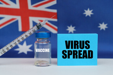 Vaccine, syringe and blue plate with the inscription - VIRUS SPREAD. In the background the flag of Australia