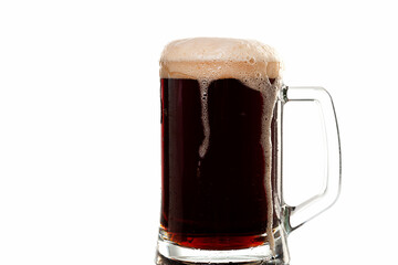 Dark beer with thick head of foam in glass beer mug on white background