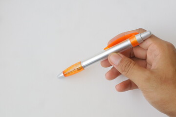 hand holding an orange pen