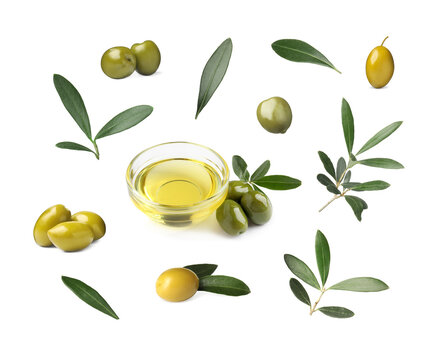 Bowl of oil, ripe olives and leaves on white background