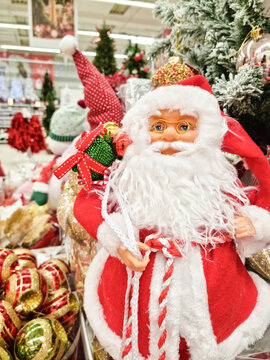 santa claus with gifts. Toy Santa Claus with a bag of gifts close-up near a Christmas tree bokeh and blurred background. Merry christmas and new year concept vertical photo