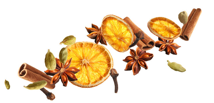 Slices of dried orange, aromatic anise stars, cinnamon, cloves and cardamom falling on white background. Banner design