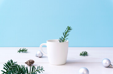 Christmas tree branches and a cup on the table. Winter, Christmas, Winter cafe, Winter menu, Christmas meals, etc. テーブルの上のコップとクリスマスツリーの枝。冬、クリスマス、冬のカフェ、冬のメニュー、クリスマス料理など