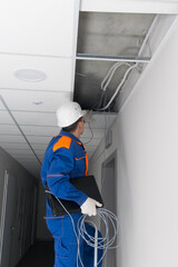 master in blue uniform, wired a WiFi router in a hidden false ceiling system