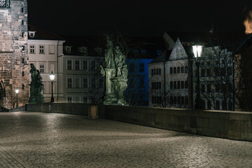 Obraz premium Street lights on the old stone Charles Bridge in the center of the city of Prague On the Vltava river at night and light from the street lights