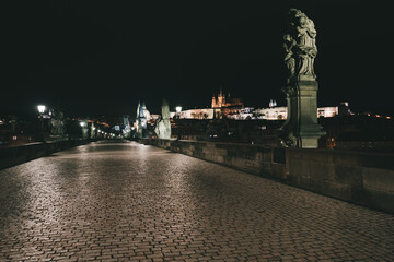 Fototapeta na wymiar Street lights on the old stone Charles Bridge in the center of the city of Prague On the Vltava river at night and light from the street lights