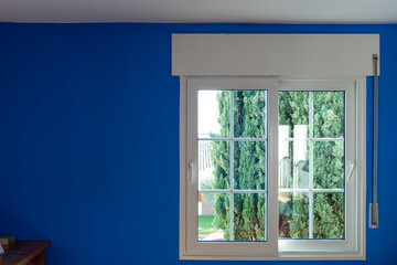 White modern window closed on a blue wall