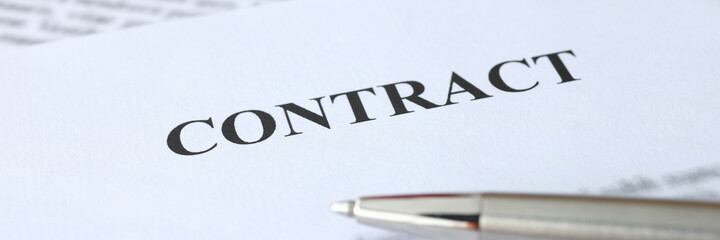 Metal ballpoint pen lying on documents with contract closeup