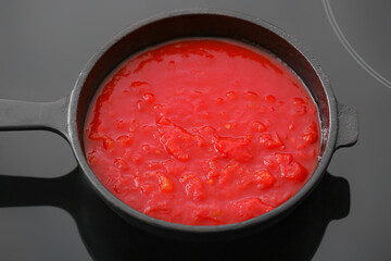 Frying pan with organic tomato sauce on stove in kitchen