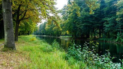 die Elde mit Bäumen in herbstlichen Farben an beiden Ufern und blaue Bruecke bei Kuppentin im...