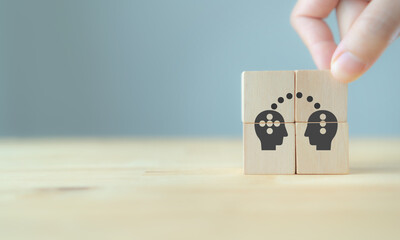Knowledge and ideas sharing between two people head icon on wooden cube. Transferring knowledge, innovation, brainstorming concept. Business strategies to technology evolution re-skill and new skill.