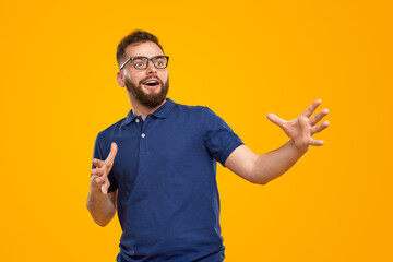 Amazed man in glasses pointing away in studio - obrazy, fototapety, plakaty