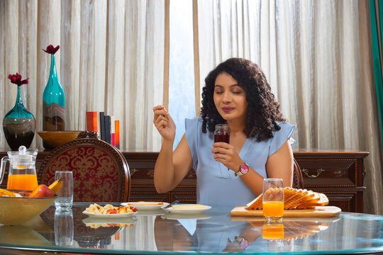 Curly hair woman smelling jam for breakfast